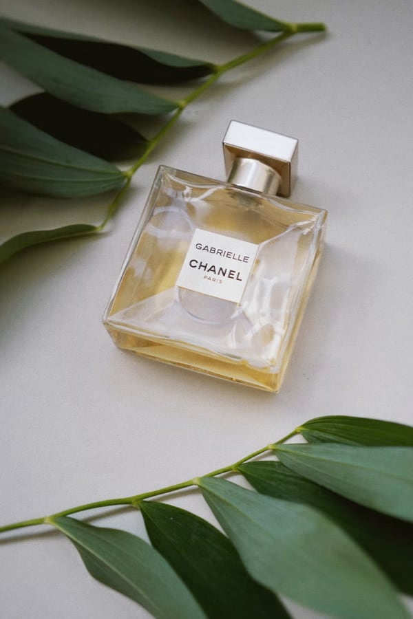 quare
						bottle of perfume laying on an off-white surface
